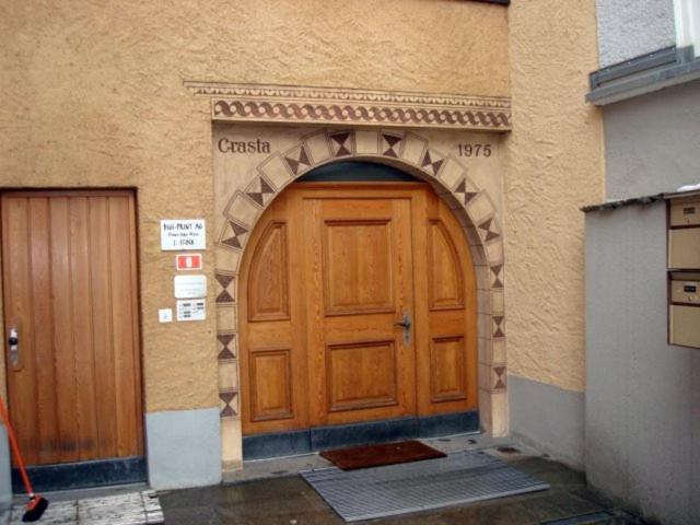 uma grande porta de madeira num edifício com um arco em Chesa Crasta 6 em Samedan