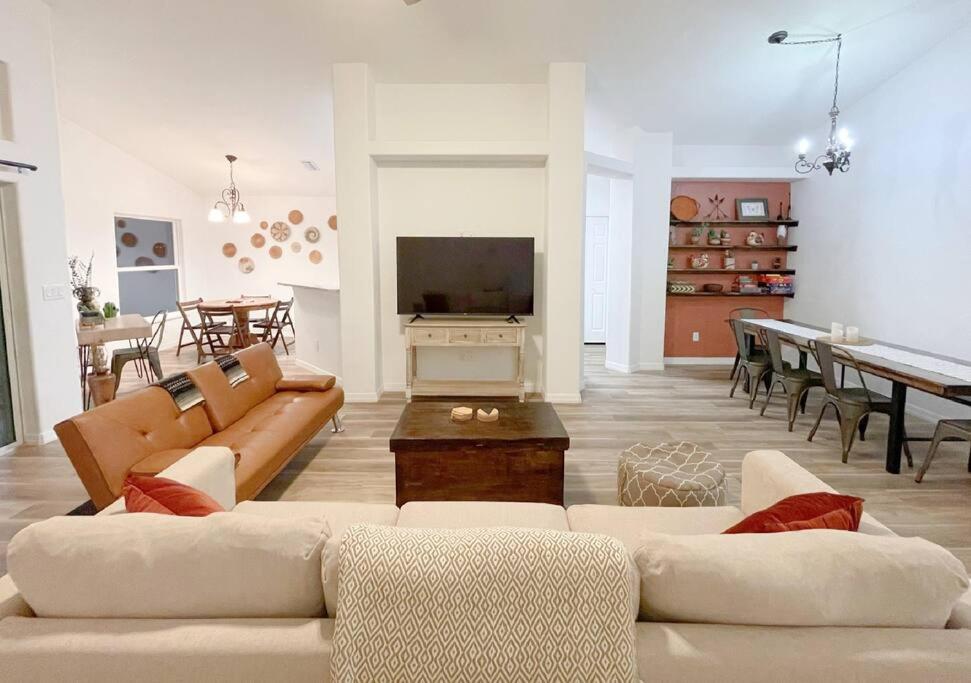 a living room with two couches and a dining room at The Sanford Ave House with fully fenced yard in Sanford