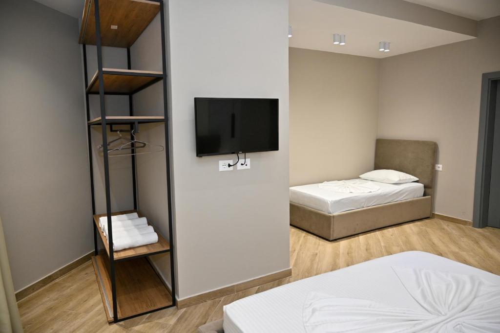 a small room with two beds and a tv at MondurO Hotel in Durrës