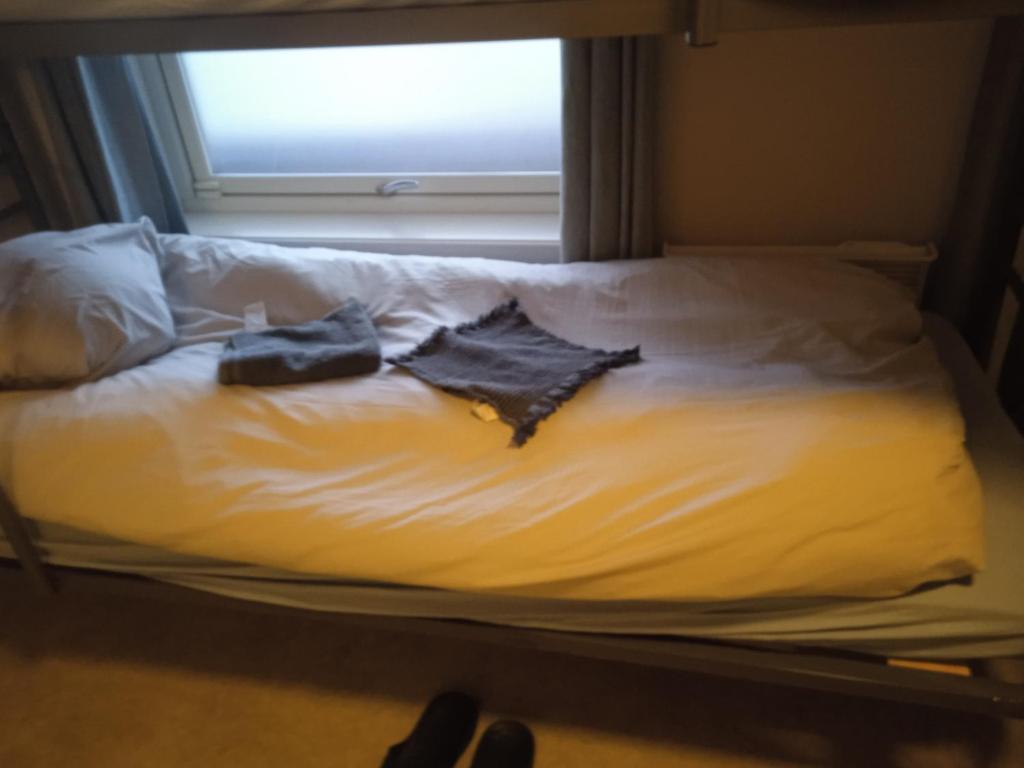 een bed met twee kleren aan en een raam bij The Haus in Moss