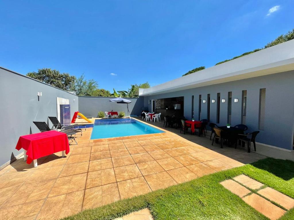 a backyard with a pool and a table and chairs at RECANTO DA LU in Maringá