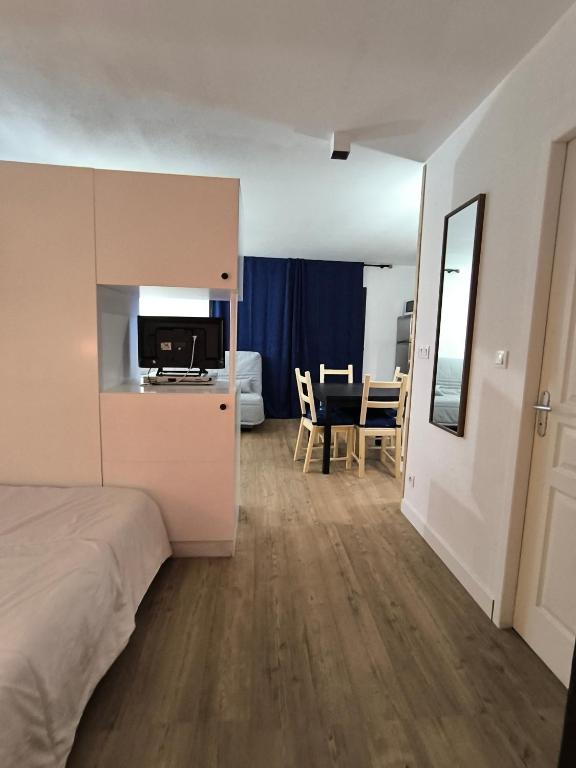 a bedroom with a bed and a kitchen and a table at studio tout équipé in Jausiers