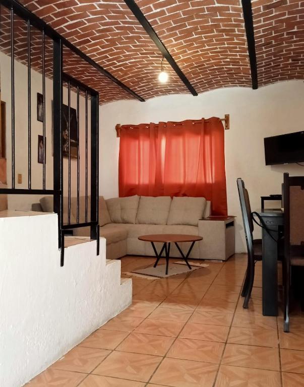 a living room with a couch and a table at Casa Brisa in Tapalpa