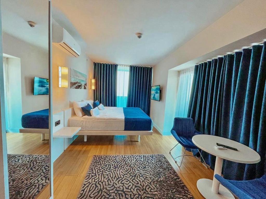 een slaapkamer met een bed, een tafel en een spiegel bij Aparthotel in Batoemi