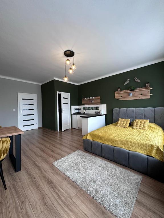 um quarto com uma cama e uma parede verde em Apartamenty w Kamienicy em Poddębice