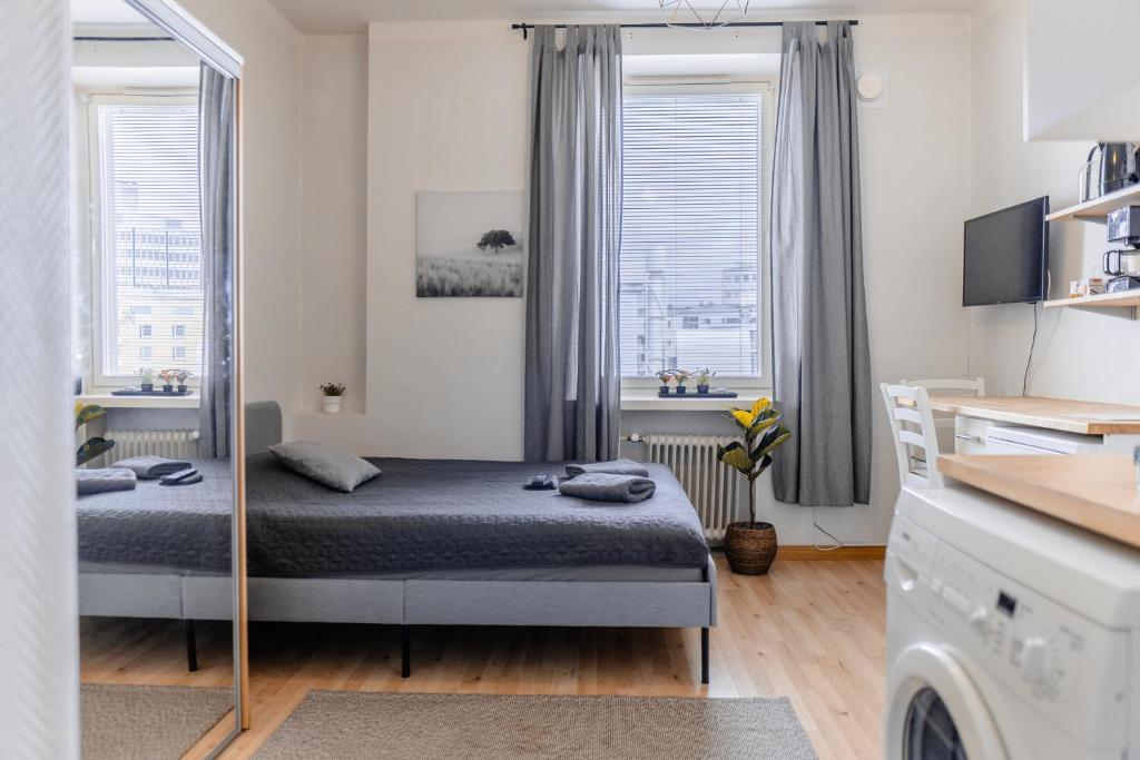 a small bedroom with a bed and a window at Nordstay - Stylish Central Studio self check-in in Helsinki