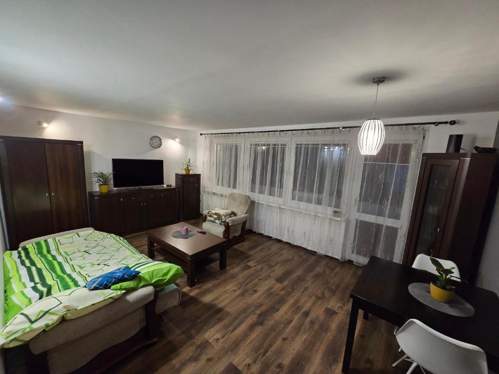 a living room with a bed and a dining room at Apartament Sosnowiec in Sosnowiec