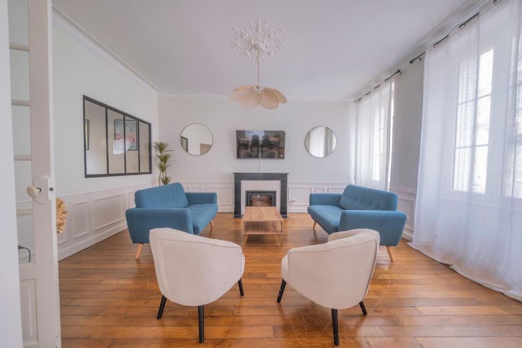uma sala de estar com cadeiras azuis e uma lareira em Le Royaume - Parking em Reims
