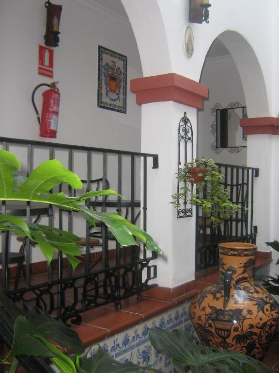 una habitación con una mesa y un jarrón con una planta en Apartamentos Turisticos Casa Cantillo, en Carmona