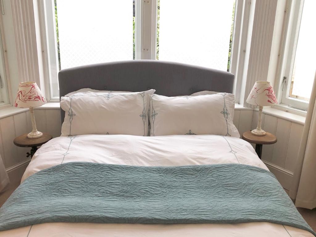 - un lit avec une couverture bleue et 2 lampes dans l'établissement East Finchley N2 apartment close to Muswell Hill & Alexandra Palace with free parking on-site, à Londres