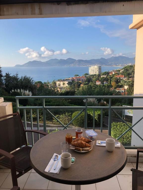 une table avec une assiette de nourriture sur un balcon dans l'établissement Comfortable apartment in Cannes, à Cannes