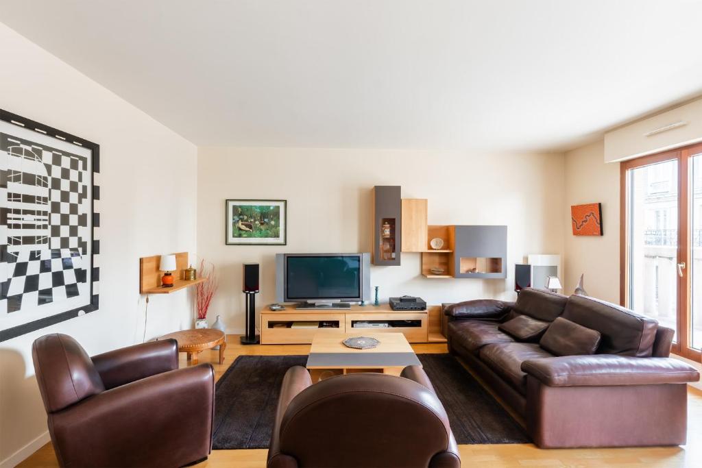 un salon avec un canapé et une télévision dans l'établissement Appartement du Théâtre - Welkeys, à Paris