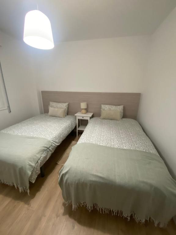2 camas individuales en una habitación con mesa en Apartamento El Nogal 2, en Tui