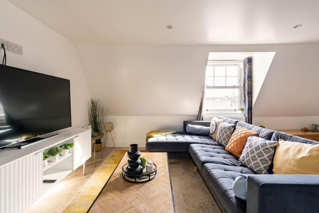 The Snug Penthouse في سيتينغبورن: غرفة معيشة مع أريكة وتلفزيون بشاشة مسطحة