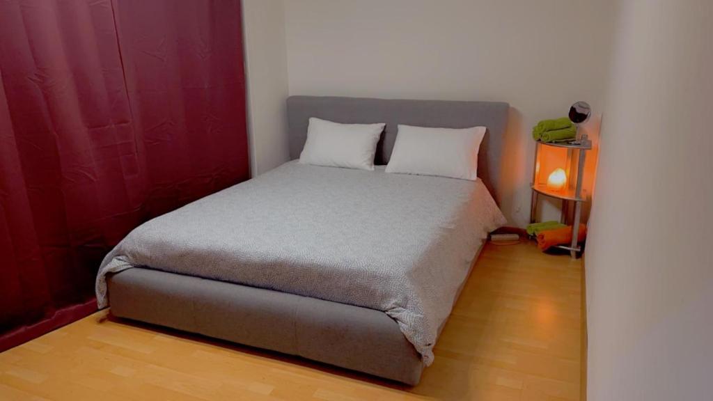 - un lit avec deux oreillers dans une petite chambre dans l'établissement Apartamento Acogedor en el centro de Basilea, à Bâle