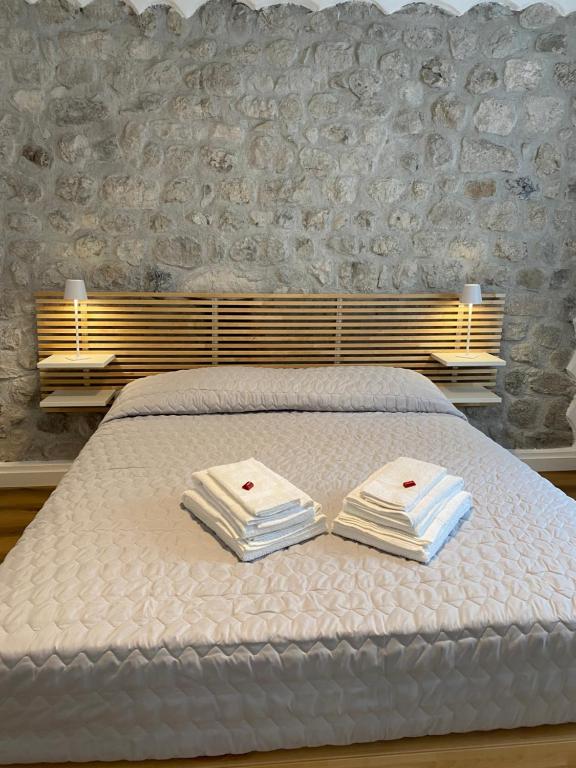 Una cama blanca con dos toallas plegables. en Appartamento Scaligeri, en Venzone