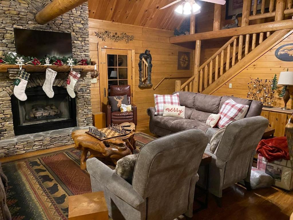 a living room with a couch and a fireplace at Beautiful 6 bdr cabin with hot tub in the Smokies! in Pigeon Forge