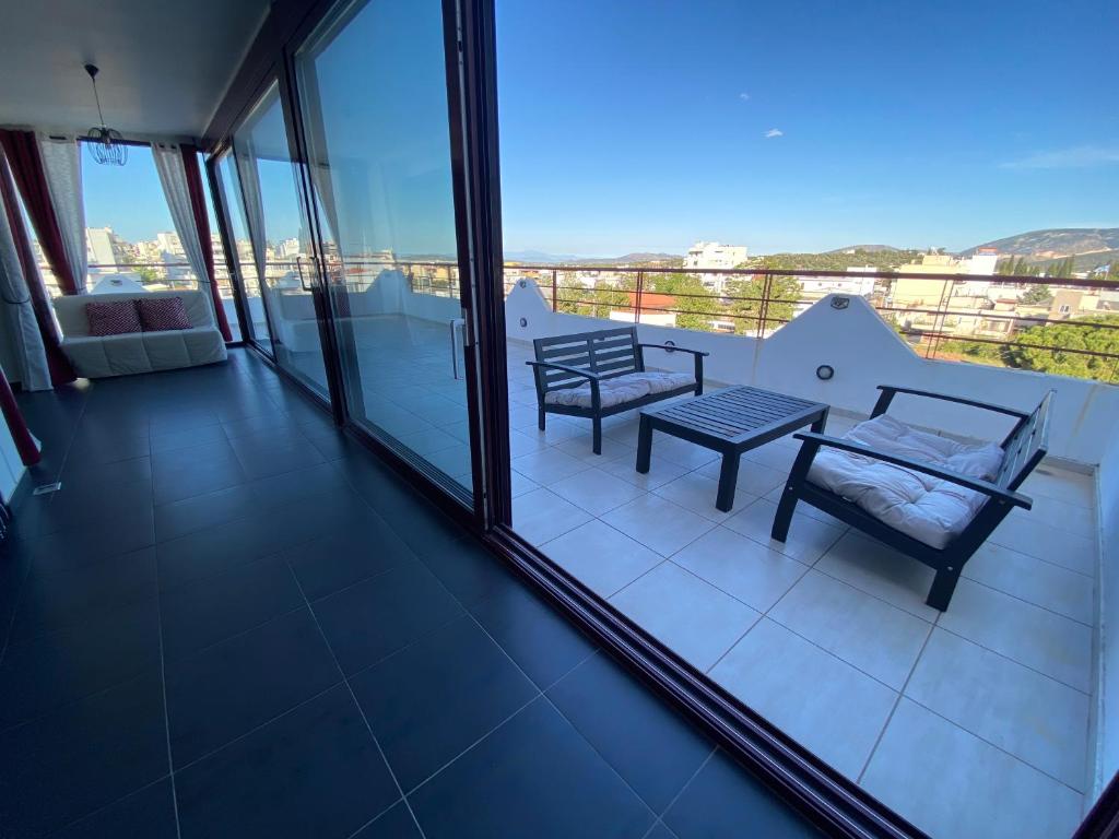 a balcony with a table and chairs and a view at Luxury view apartment 10min from Athens airport in Koropi
