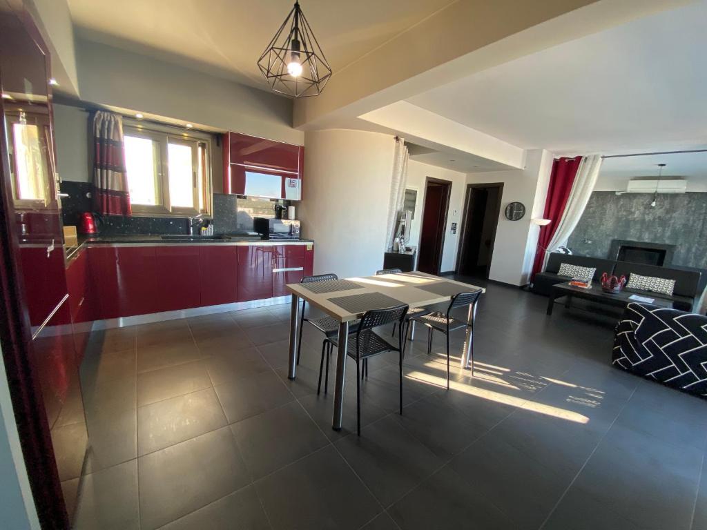 a dining room and kitchen with a table and chairs at Luxury view apartment 10min from Athens airport in Koropi