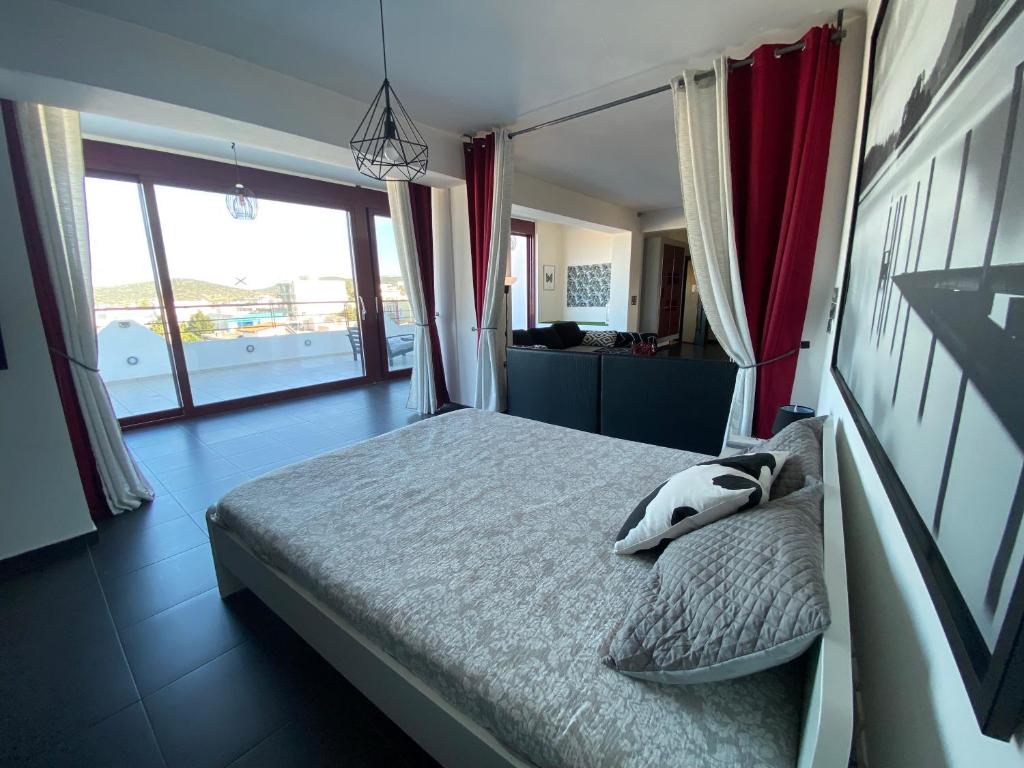 a bedroom with a bed with pillows on it at Luxury view apartment 10min from Athens airport in Koropi