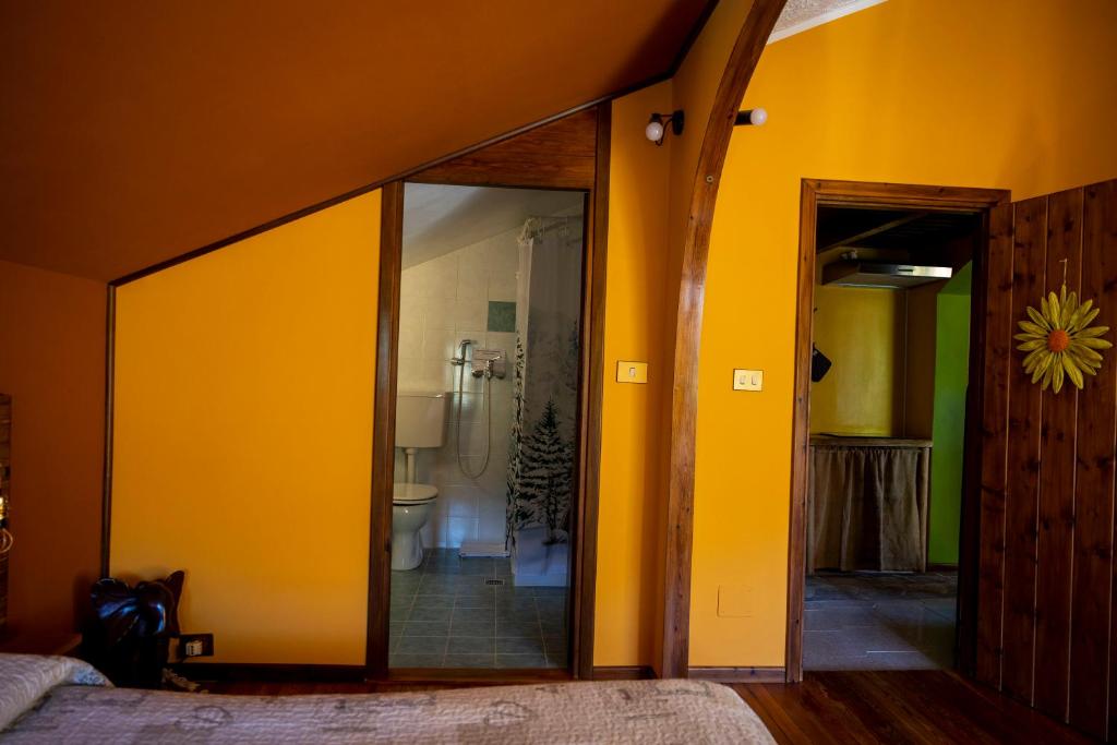a bedroom with yellow walls and a sliding glass door at B&B Pian Savin in Giaveno