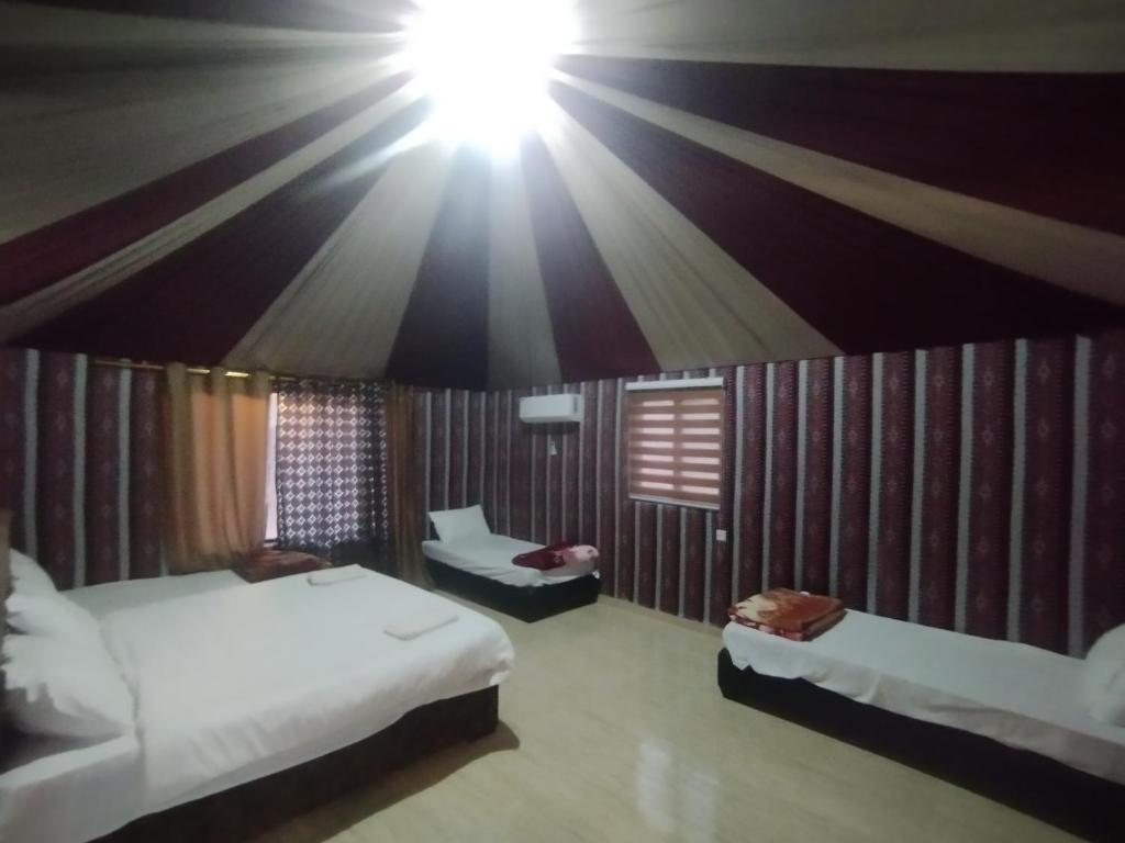 a bedroom with two beds and a light on the ceiling at Waid Rum Jordan Jordan in Wadi Rum