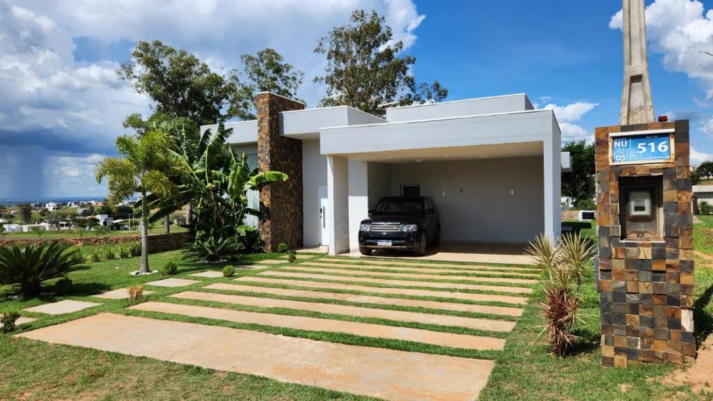 a house with a car parked in the garage at Casa aconchegante perto do Clube Marina in Palmeiras