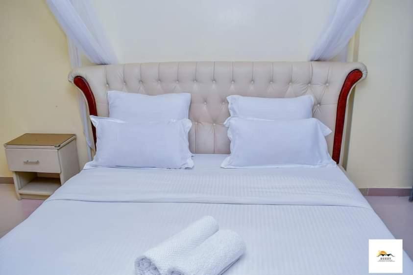 Cama ou camas em um quarto em Suzzy Cozy Apartments Milimani