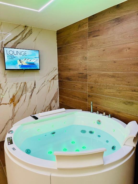 a jacuzzi tub in a bathroom with a tv at Suite169 Gold in Bari