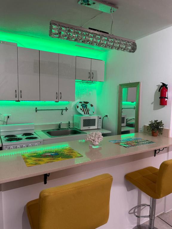 eine Küche mit grünen Lichtern auf einer Theke in der Unterkunft Downtown Condado Tropical Studio in San Juan