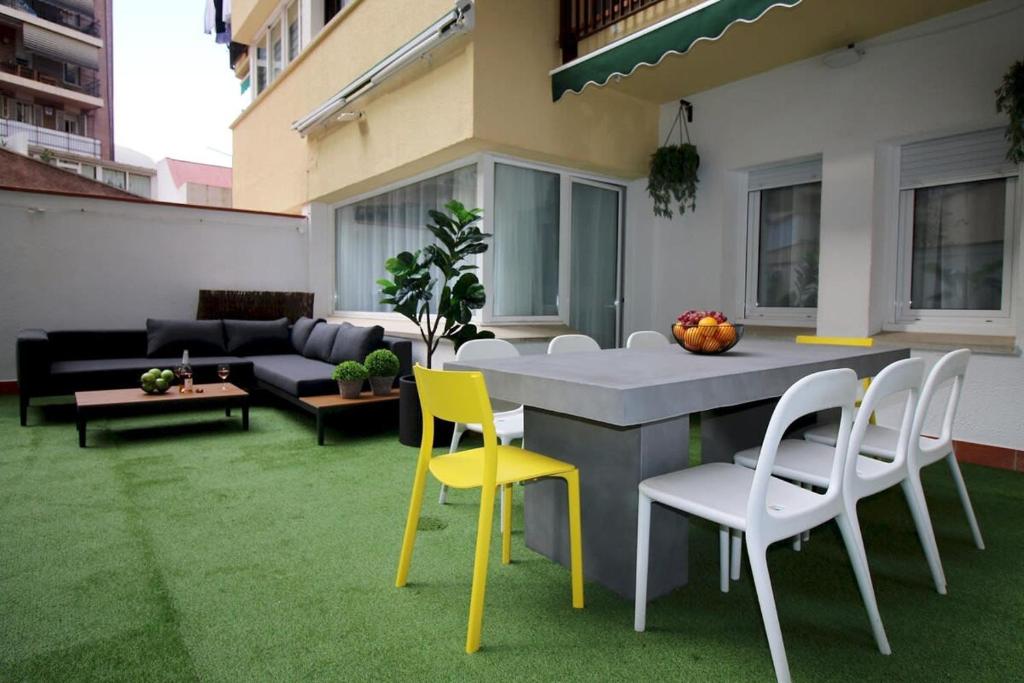 eine Terrasse mit Stühlen, einem Tisch und einem Sofa in der Unterkunft Wonderful apartment in Plaza España in Barcelona