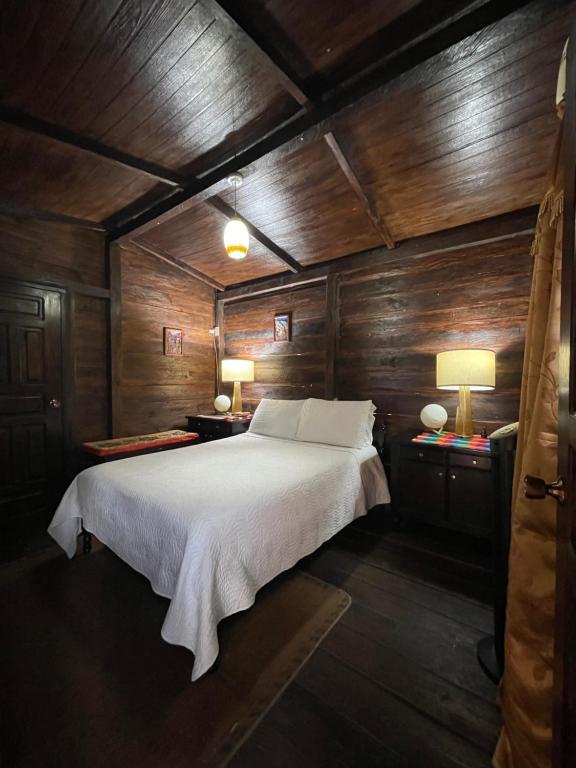 - une chambre avec un lit dans un mur en bois dans l'établissement Cabaña entre orquídeas, à Valle de Ángeles