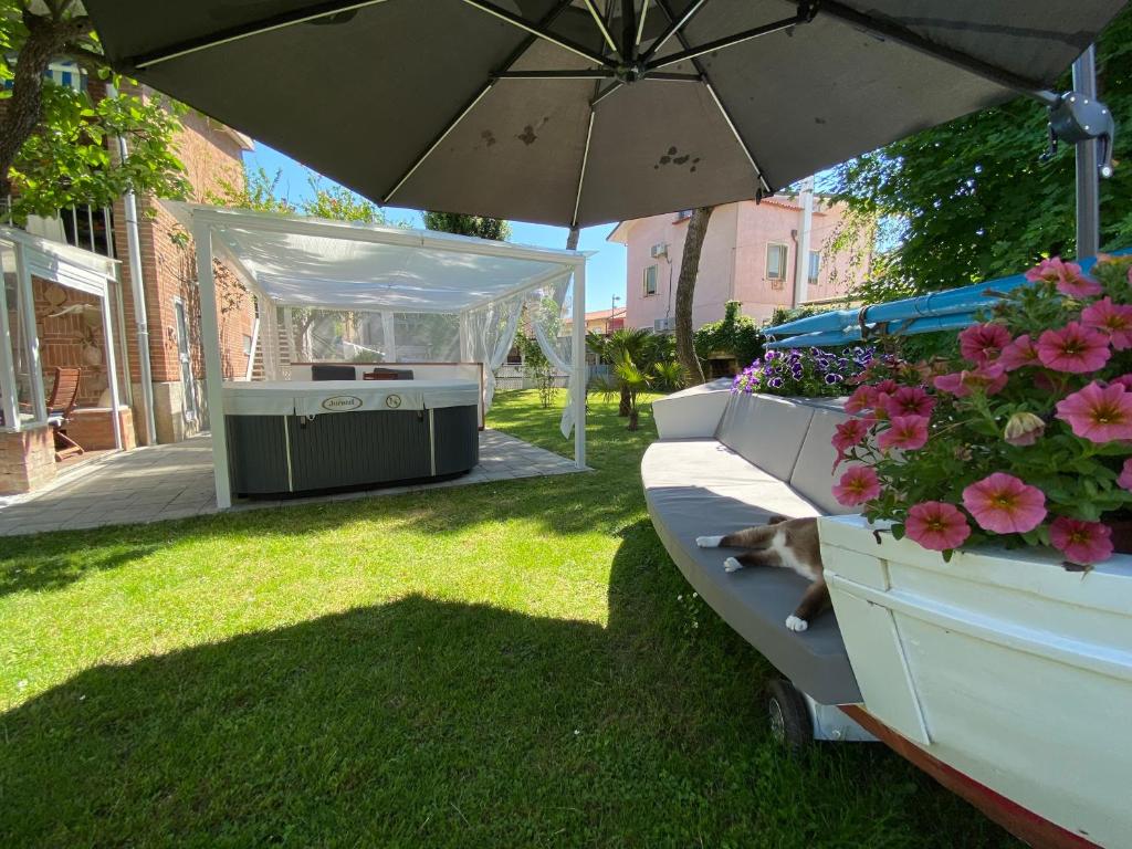 a dog laying on the grass under an umbrella at B&B and Sail in Caorle