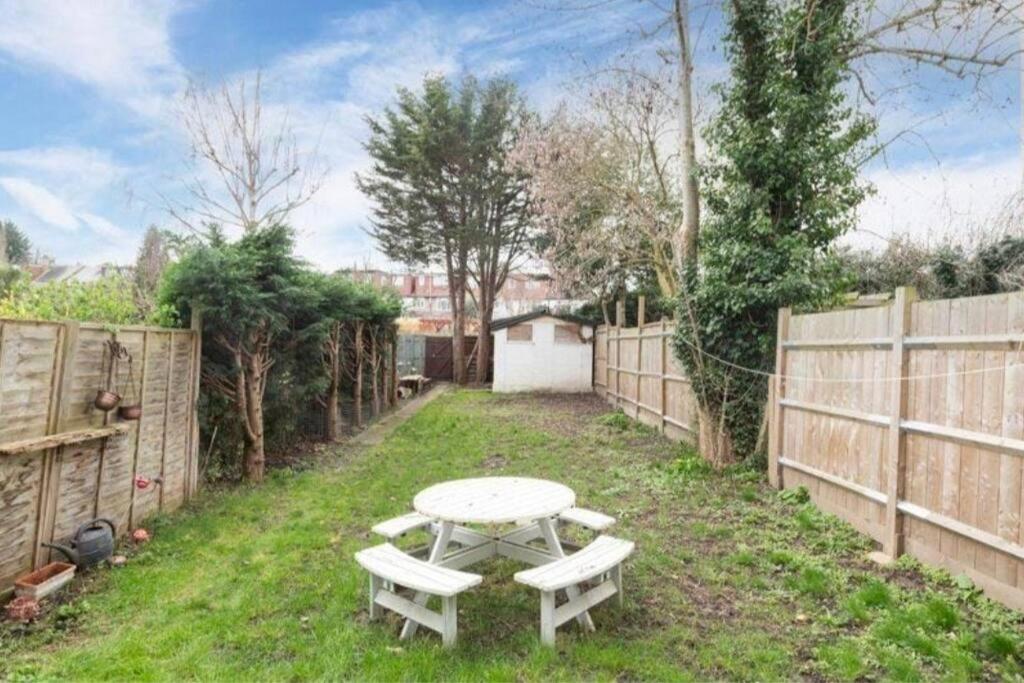 uma mesa de piquenique num quintal com uma cerca em Charming 3 Bed House Bromley London em Bromley