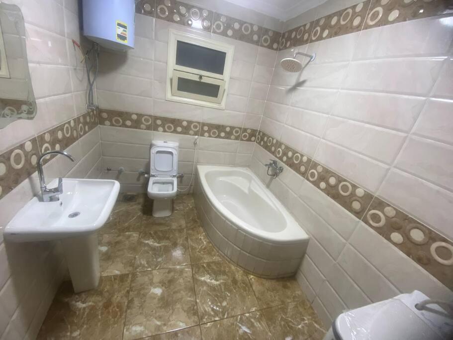 uma casa de banho com um lavatório, um WC e um bidé em Pyramids Apartment no Cairo