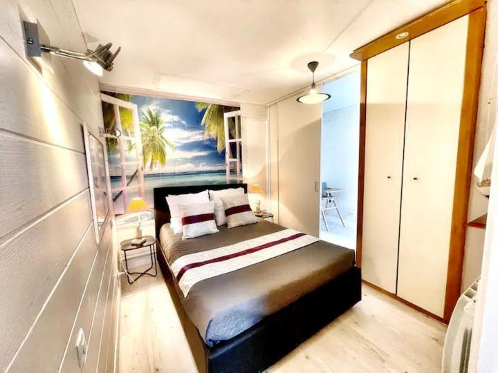 a bedroom with a bed with a painting on the wall at La Casa Vega - Casino, plage et parking in Villers-sur-Mer