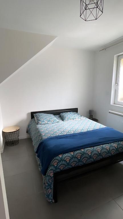 - une chambre avec un lit doté d'une couette bleue et d'une fenêtre dans l'établissement Belle Nuit, à Bout dʼAmont