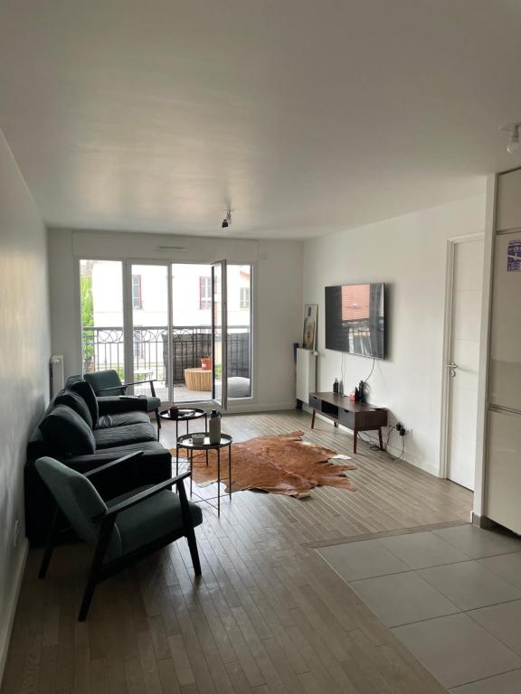 ein Wohnzimmer mit einem Sofa und einem Tisch in der Unterkunft Belle Appartement à Suresnes in Suresnes