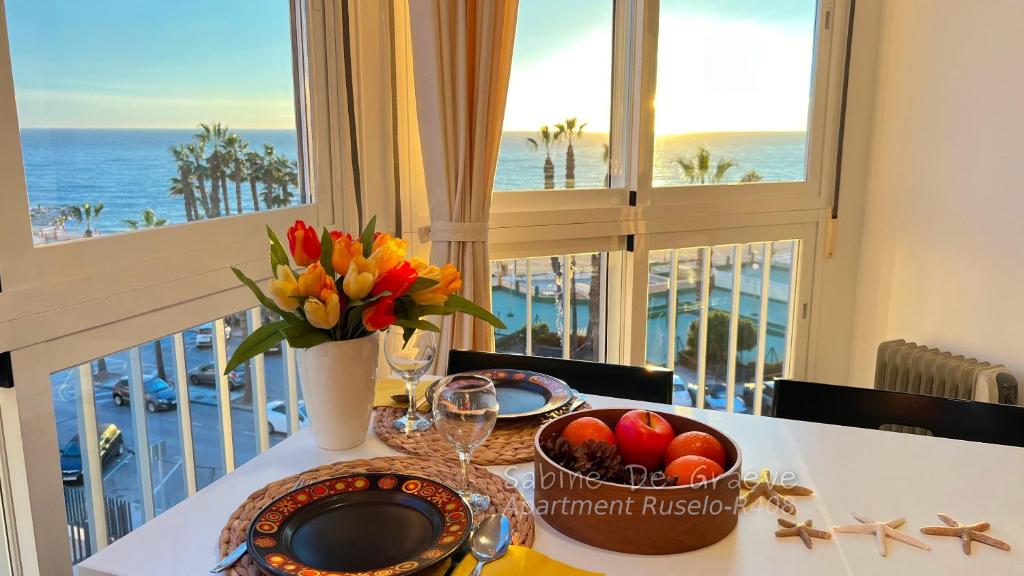 a table with a bowl of fruit and flowers on a balcony at Ruselo Loft-Studio R607 or Apart 1 bedroom R408 Beachfront in Torrox Costa