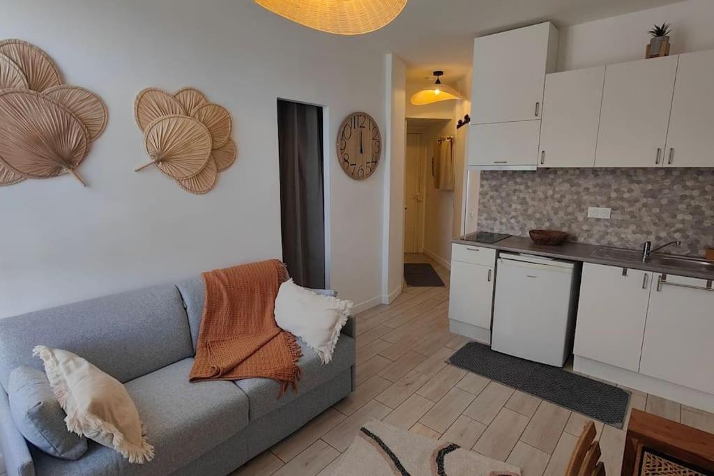 a living room with a couch and a kitchen at Cocoon urbain : Aux portes des JO et de Disney in Vaires-sur-Marne