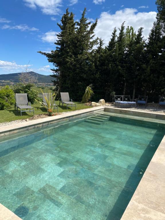 une piscine avec de l'eau bleue dans une cour dans l'établissement Gîtes chez Marceau, à Rasteau