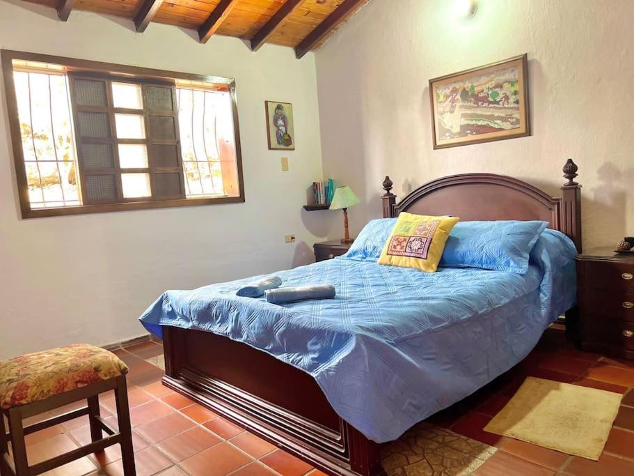 a bedroom with a bed with a blue comforter at Hermosa habitación Las Palmas - Zapatoca in Zapatoca