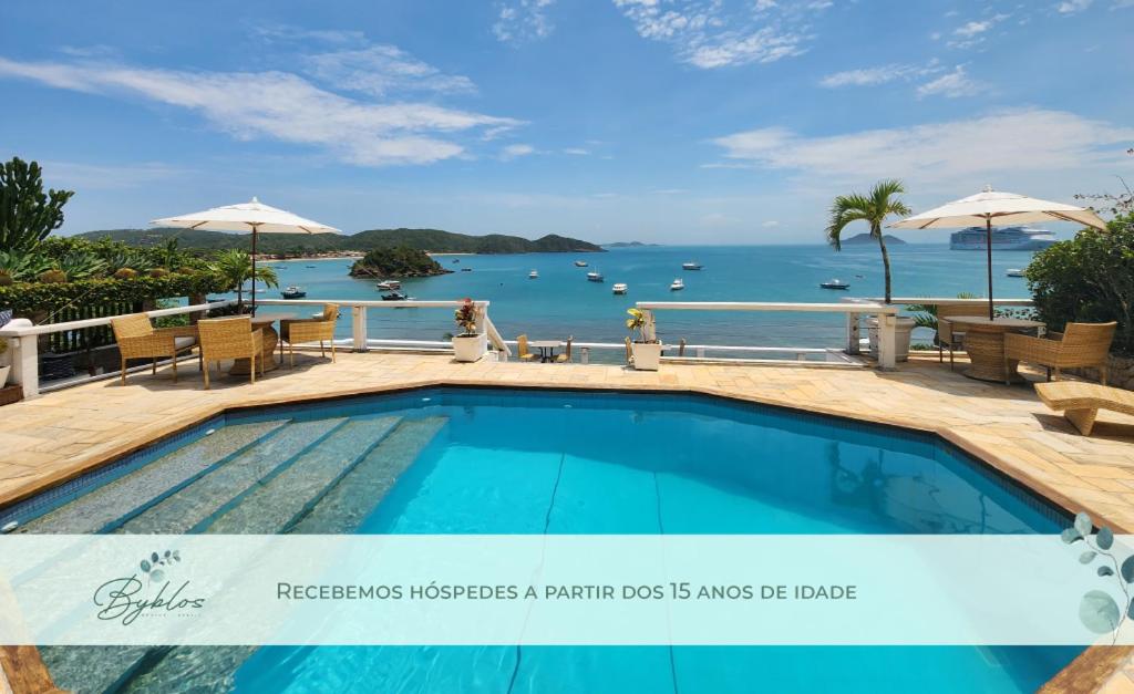 a swimming pool with a view of the ocean at Byblos Pousada in Búzios