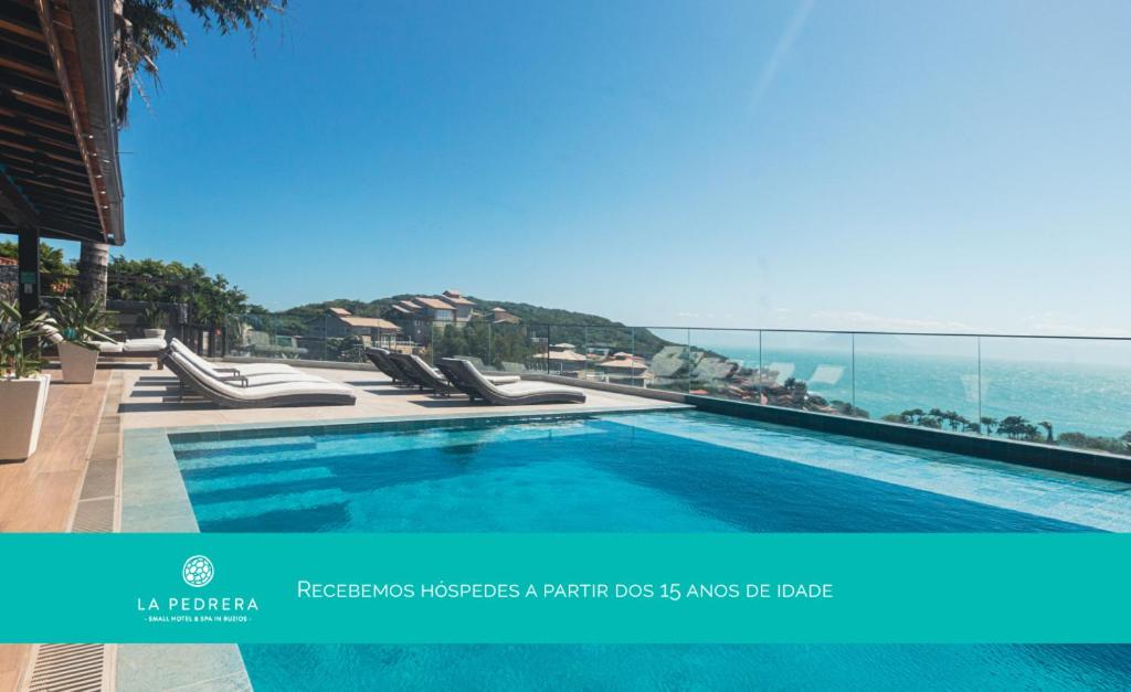 a swimming pool with a view of the ocean at La Pedrera Small Hotel & Spa in Búzios