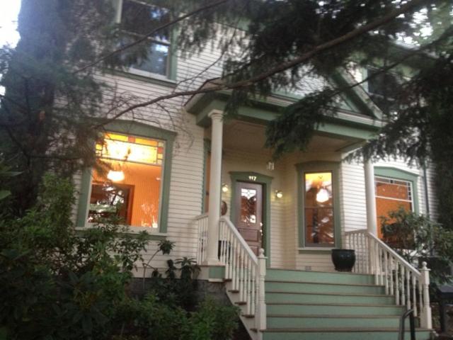a white house with a front porch and stairs at Nightingales Inn in Ashland