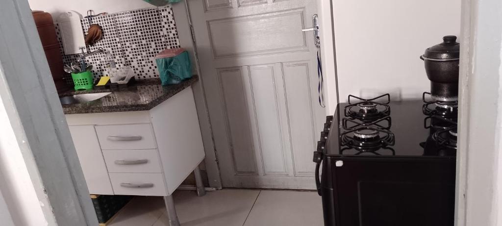 cocina con fogones negros y nevera negra en Rafa's hostel en São Paulo