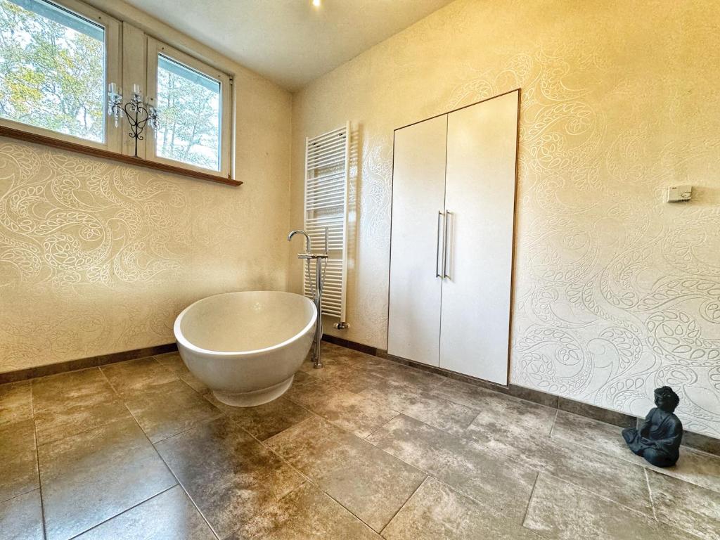 a bathroom with a large tub in the corner of the room at 5 Sterne Bahnhoftraum, Appartement "Waldgarten" 145qm, großer Garten in Braunfels