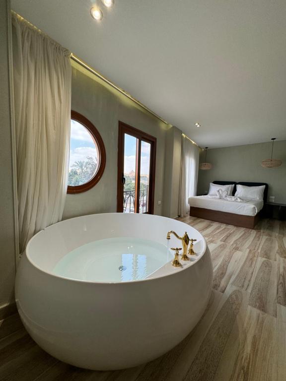 a large white bath tub in a room with a bed at Jimmy Pyramids Hotel in Cairo