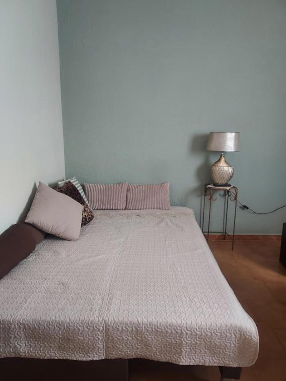 Una cama con almohadas rosas y una mesa en una habitación en Maison de Couture, en Kalymnos