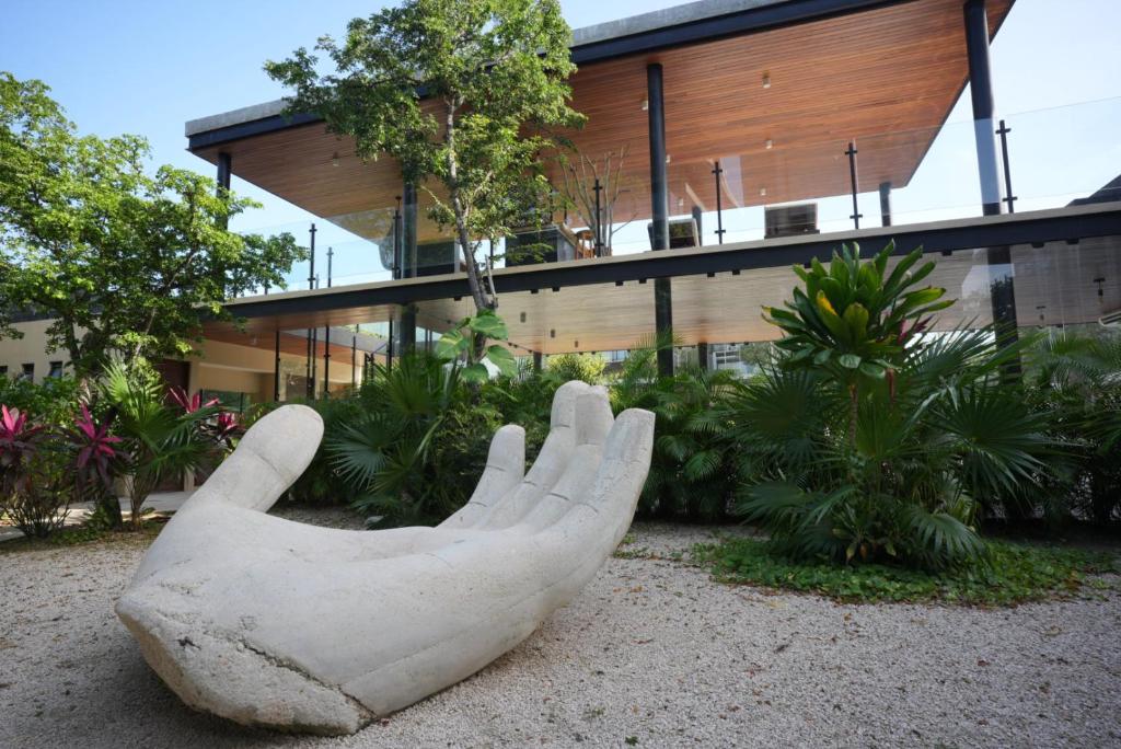 une statue de main devant un bâtiment dans l'établissement Nook Tulum Luxury Condohotel by Marea, à Tulum